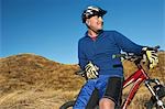 Man leaning on bicycle in field