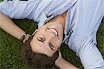 Smiling Businessman Lying Down on Grass