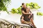 Tourist Couple on Stone Wall in Granada, Spain, front view