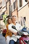 Couple d'âge mûr sur la trottinette dans la rue en portrait de Rome (Italie),