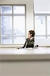Businessman sitting at office desk Talking on Cell Phone