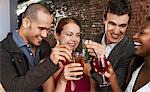 Two couples toasting, standing in bar