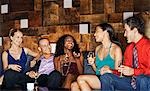 Group of friends talking, sitting on couch in bar