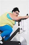 Femme obèse sur vélo d'appartement