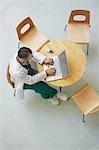 Doctor Using Laptop in cafeteria, view from above