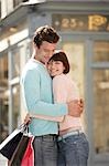 Couple with shopping bags embracing on street corner