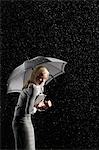 Femme d'affaires arrondir vers le bas sous le parapluie de protection contre la pluie