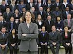 Business woman standing in front of business people sitting in bleachers, portrait