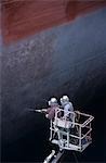 Deux personnes debout dans le godet de grue grand navire peinture