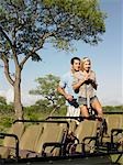 Couple on safari, standing in jeep, woman holding binoculars