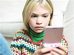 Young Girl concentrating, Playing Handheld Video Game