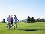 Trois jeunes golfeurs sur le parcours