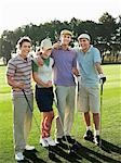 Gruppe der jungen Golfer posiert auf Platz