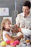 Mother and Daughter Making Cupcakes in kitchen