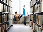 Teenage boy doing homework in library