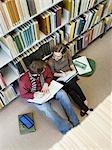 Students sitting on floor, doing homework in library