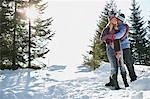 Couple debout sur une colline couverte de neige