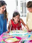 Girl (8-12) blowing out birthday candles