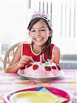 Portrait of girl (7-9) with birthday cake, laughing