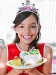 Porträt von Girl (7-9) mit Stück Geburtstagstorte auf Teller, Lächeln