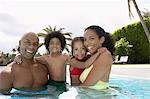 Parents with son and daughter (5-6 years) in pool, portrait