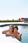 Two teenage girls (16-17) in swimming pool, portrait