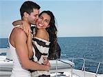 Young couple embracing on yacht, man kissing woman