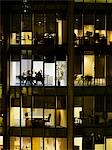 Group of business people at meeting in office, view from building exterior