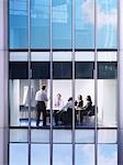 Group of business people at meeting in office, view from building exterior