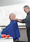 Barber removing cape from man in barber shop
