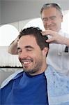 Barber preparing man for haircut in barber shop