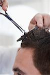 Barber cutting mans hair in barber shop