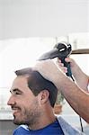 Barber drying mans hair in barber shop