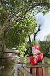 Portrait de costume de pirate habilement jeune garçon (7-9), s'appuyant sur la porte de jardin