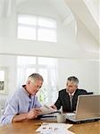 Senior man sitting at table with financial advisor