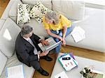 Woman sitting on sofa with financial advisor, elevated view