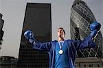 Boxer porte debout médaille d'or en face de gratte-ciels du centre-ville, faible angle vue, Londres, Angleterre