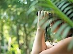 Jeune femme avec des jumelles dans la forêt tropicale, vue latérale