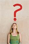 Woman leaning against wall with painted question mark