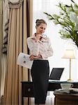 Business woman holding document, standing in home office