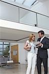 Real estate agent showing woman plan of new home