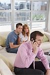 Real estate agent using mobile phone with couple in new home