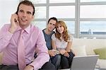 Real estate agent using mobile phone with couple in new home