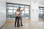 Couple photographing empty apartment