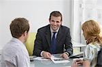 Couple with real estate agent in office