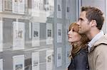 Couple looking in window outside estate agents