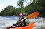 Femme kayak en rivière