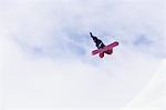 Person on snowboard, jumping, view from below