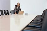 Business woman using laptop in board room