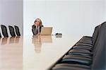 Business woman sitting by laptop in board room